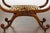 A pair of English Regency mahogany stools from the 19th century with large scrolling arms and legs, carved foliage and...
