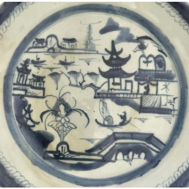 A classic 19th century Chinese Canton blue and white porcelain plate, hand painted with a tranquil riverside village scene...