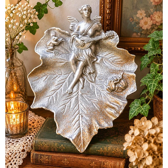 Charming vintage cast metal wall plaque or decorative tray featuring a winged fairy seated upon a large textured leaf...
