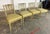 This set of four Neoclassical-style dining chairs features elegant arrow-back construction, tapered legs, and a softly...