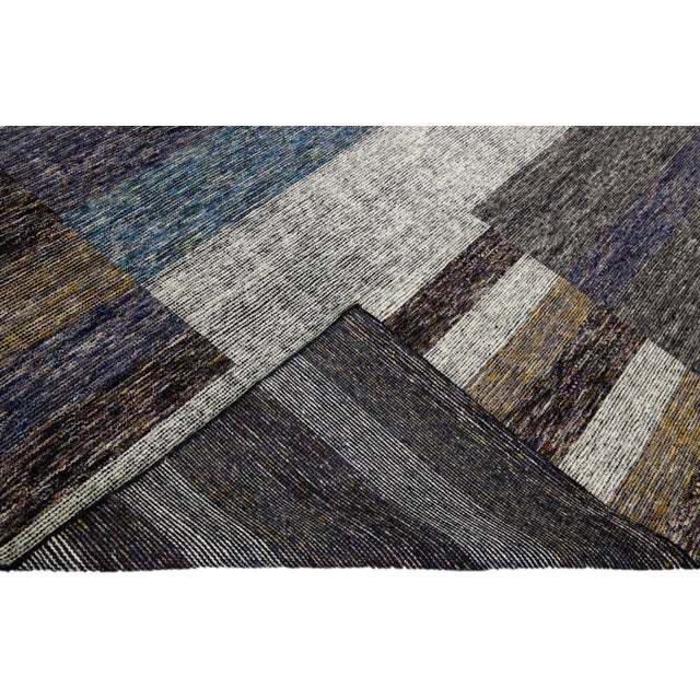 Beautiful modern Apadana's Safi Collection hand-knotted wool rug with an earthy colors field. This Modern rug has blue,...