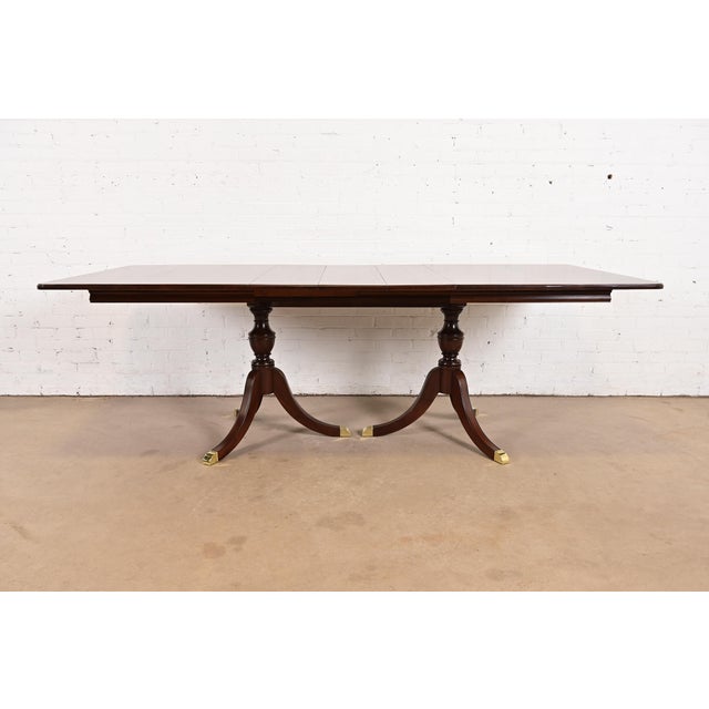 An exceptional Georgian or Regency style double pedestal extension dining table In the manner of Baker Furniture USA,...