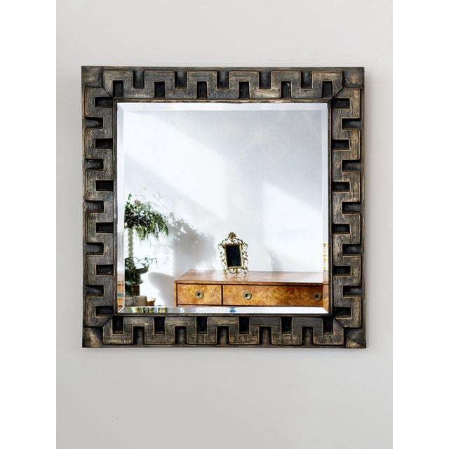 Mid Century hammered tin wall mirror. Greek key pattern with dark patinated finish and beveled glass mirror.