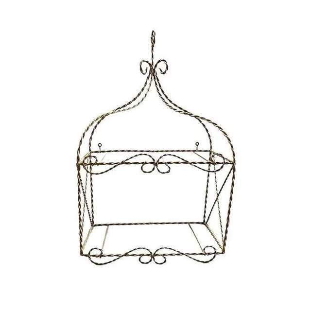 A small hanging wall shelf created from gold twisted metal. This shelf will be great in a bathroom for holding beauty...