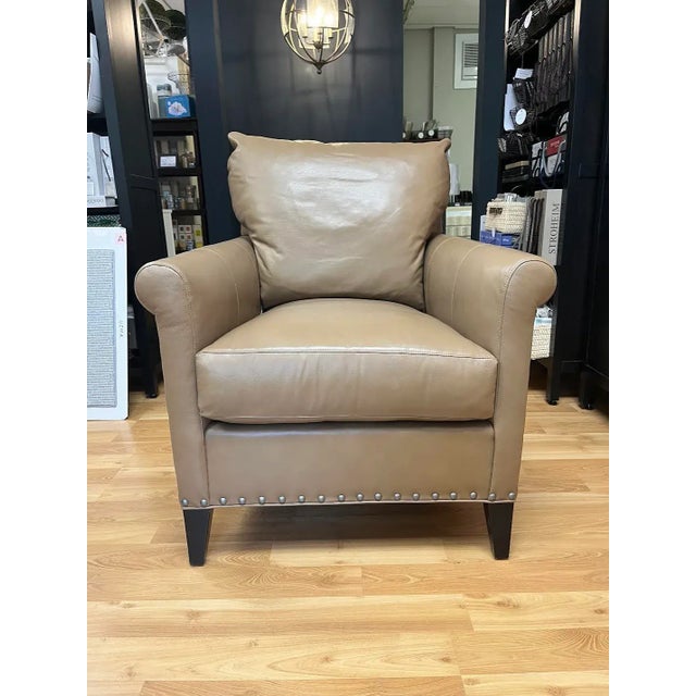 Leather chair: Nickel nail trim at base; Rolled arms; 8-way hand tied seat cushion; One border-French seam; Wood legs....