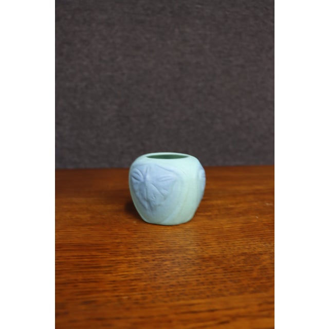 Small Van Briggle pottery vase with a rounded form and raised butterfly, or luna moth, decoration wrapping around the...