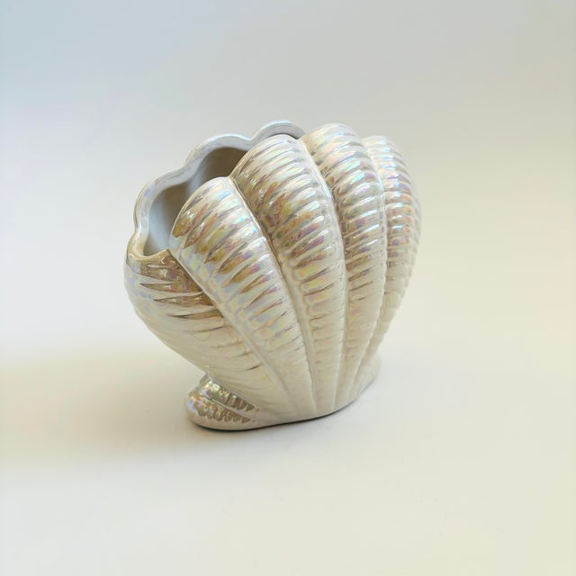A wonderful vintage ceramic vase in the shape of a shell. Features a beautiful white iridescent glossy finish. Measures...
