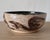A distinctive American studio pottery bowl from New York, decorated with expressive dark brown brushwork over a warm...