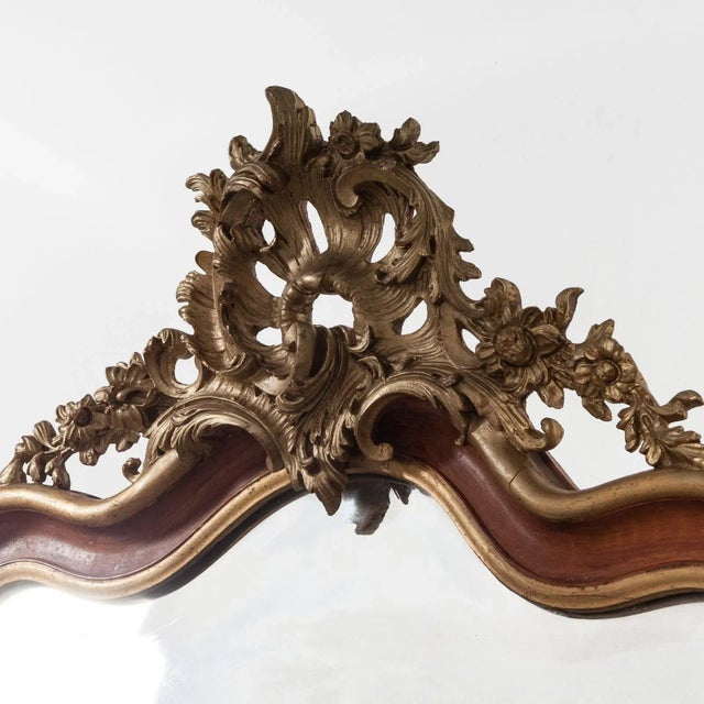 This is a lovely and very decorative 19th century Italian Rococo style gilt wood mirror. It is masterfully crafted in hand...