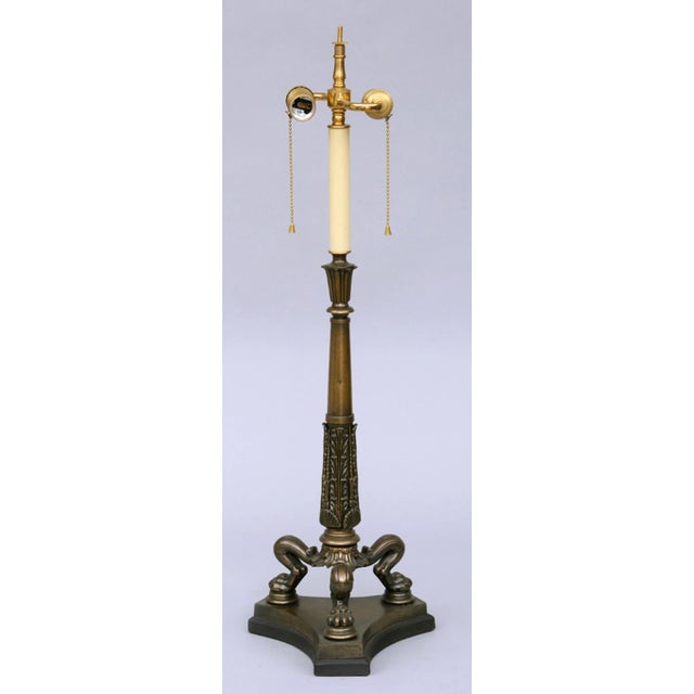 Regency bronze lamp with tall foliate and shell patterned column, tripod paw feet on concave-shaped base with black paper...