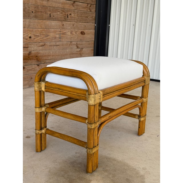 A beautiful vintage rattan ottoman / footstool newly refinished and custom upholstered in an elegant off-white Sunbrella...