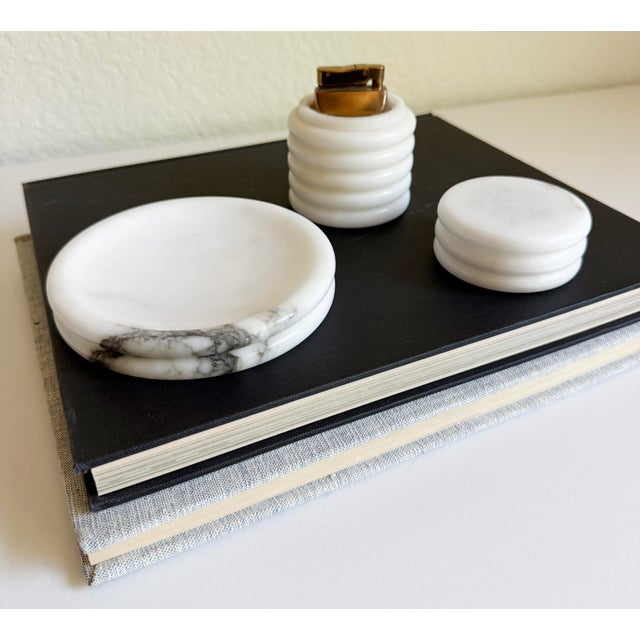 A handsome table lighter and ashtray set made of Carrara marble with ribbed bandings. Remove the lighter's lid to reveal a...