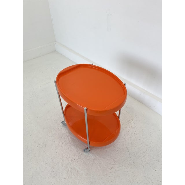 The presented Space Age vintage bar cart from the 1960s shows a chromed tube steel frame and four wheels for mobility....