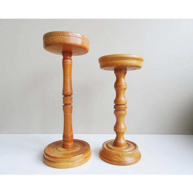 These solid wood columns are two turned wooden stands from the mid century. The bases in different heights are perfect as...