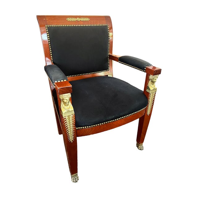 This wooden chair has an upholstered seat and back and features many Neoclassical motifs. From its paw feet to its...