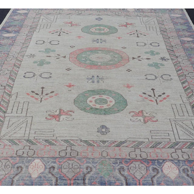 Finely hand knotted Khotan Rug with Circular Medallions in Shades of Purple, light Green, salmon, medium green and Cream....