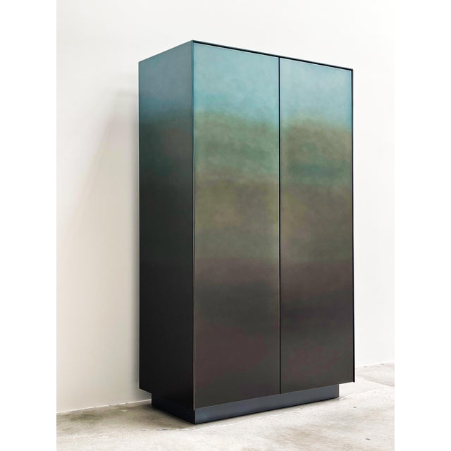 DeCastelli cabinet cladded with stainless steel ombre metal and titanium oak shelving.