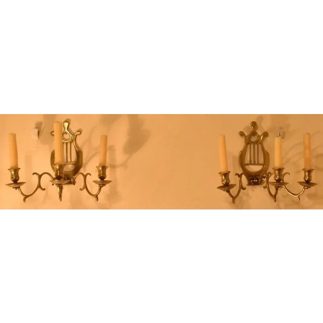 English cast brass sconces, 19th century, lyre back design with scrolling arms and candle holders. This is a pair. These...
