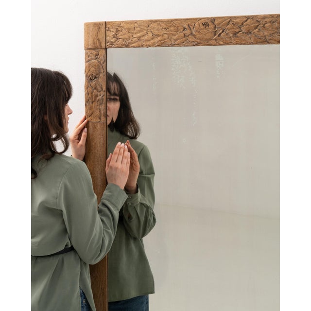 A circa 1900 French wall mirror constructed in oak, featuring a simple and well-proportioned frame. The design emphasizes...