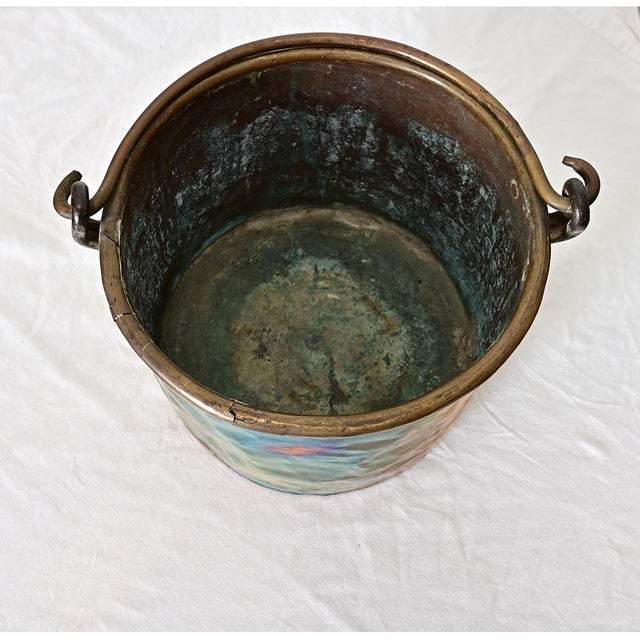 An antique French brass cooking pot with handle for suspending over the fire, dating to the second half of the 19th...