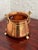 A small hand hammered copper cauldron with a brass handle and feet, warm and glowing on a hearth or in a window. Use it to...
