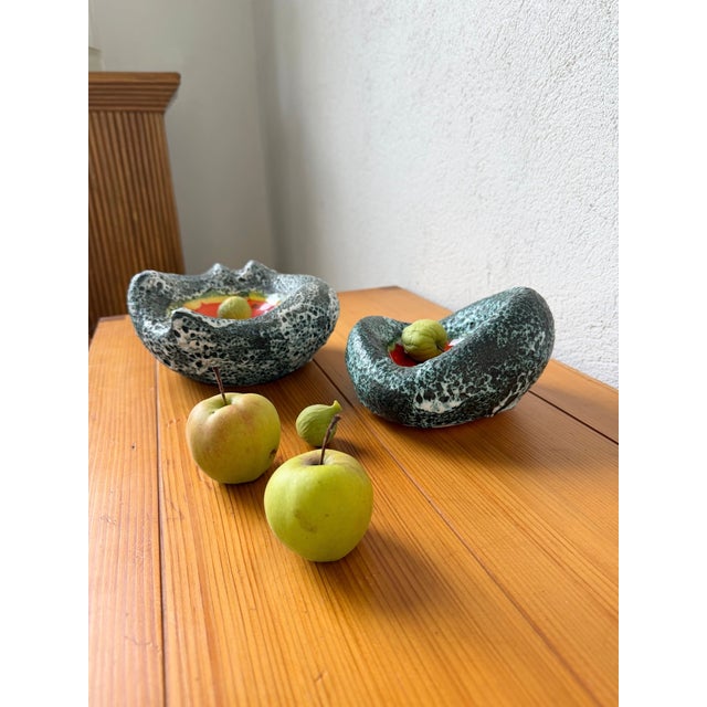 Set of two blue fatlava ashtrays/trinket trays with orange and yellow glazed ceramic centers, dating from the 1960s. In...