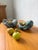 Set of two blue fatlava ashtrays/trinket trays with orange and yellow glazed ceramic centers, dating from the 1960s. In...