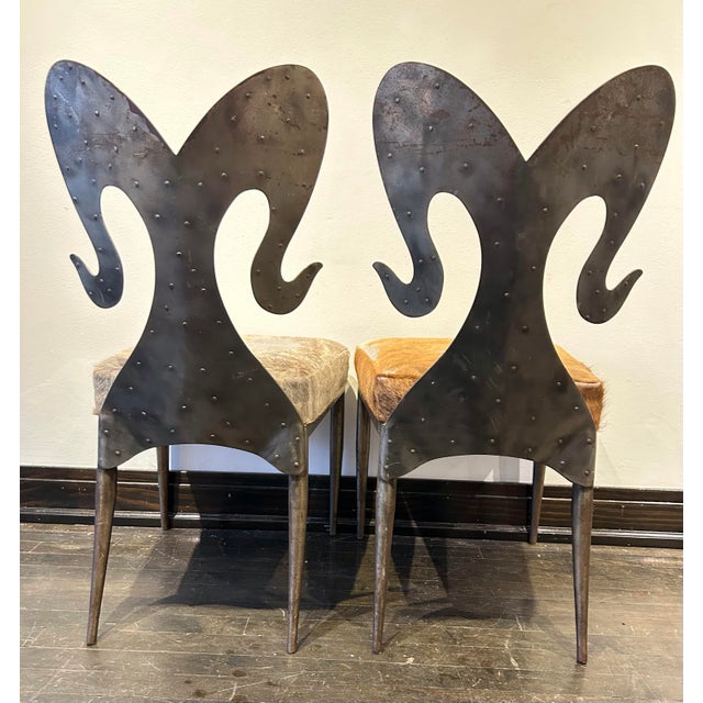 Pair of side custom made textured steel chairs with ram horn shaped backs. Seats upholstered in cowhide fur. Natural...