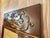 Elegant Empire-style wall mirror crafted in richly figured mahogany with a molded frame and an ornate brass ormolu crest...