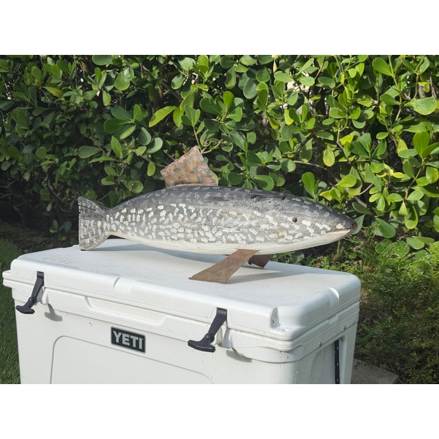 A substantial hand-carved folk art fish sculpture with hand-forged steel fins and a weathered painted finish. Visible...