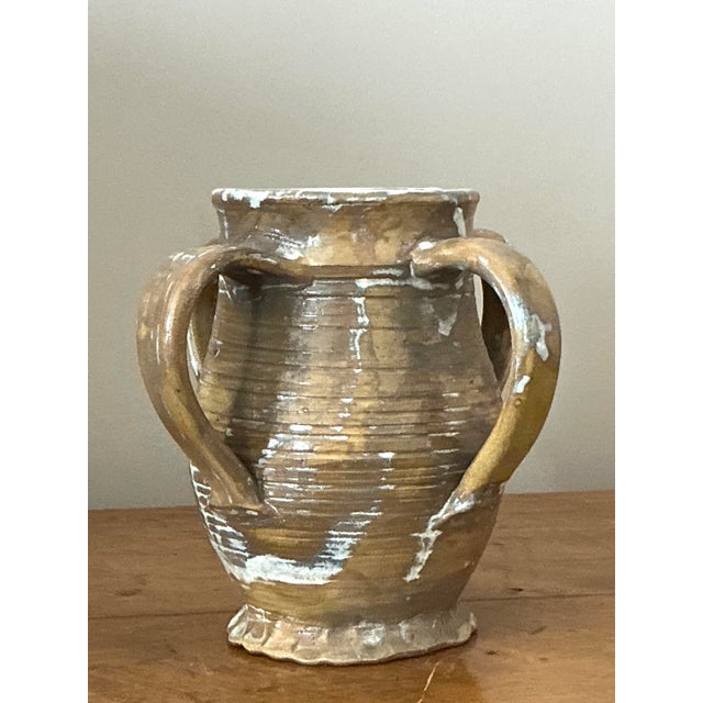 Evoke the rustic charm of a Mediterranean villa with this captivating vintage studio pottery vase. Its classical amphora-...
