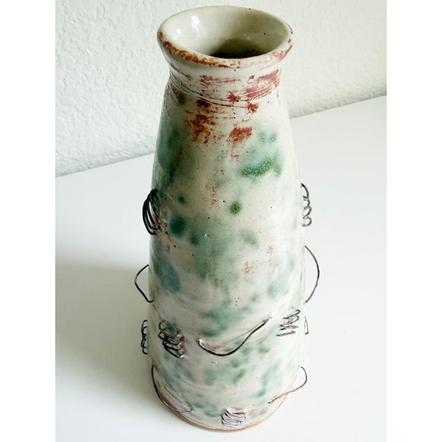 Vintage studio pottery ceramic vase with embedded steel wire accents, circa 1990s. The wire has been woven around the vase...