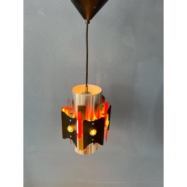Metal mid century pendant lamp by Lakro Amstelveen. The lamp is made out of steel and has orange, black and silver...