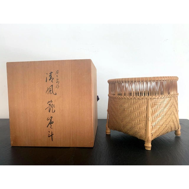 A handwoven bamboo basket by Japanese bamboo artist Higashi Takesonosai (1915-2003), in the form of a traditional rice...