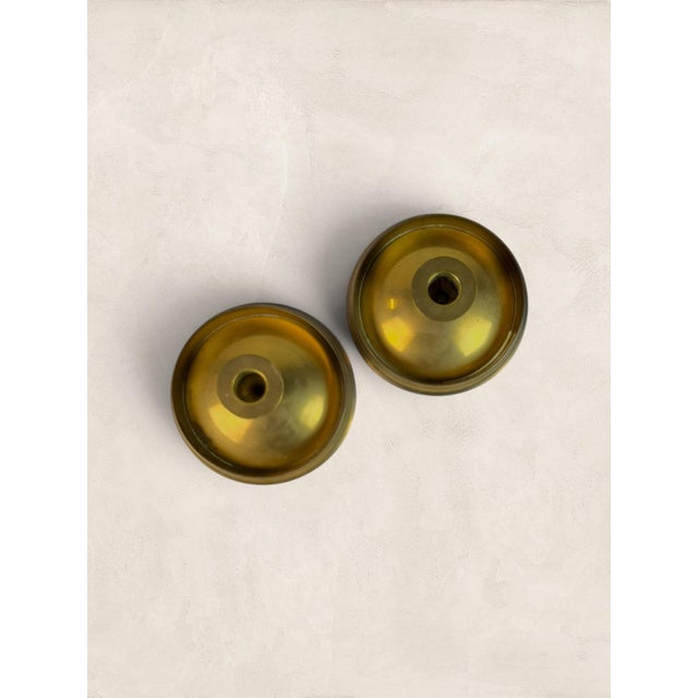 A charming pair of English Victorian brass chambersticks, dating to circa 1890. Crafted from solid brass, each features a...