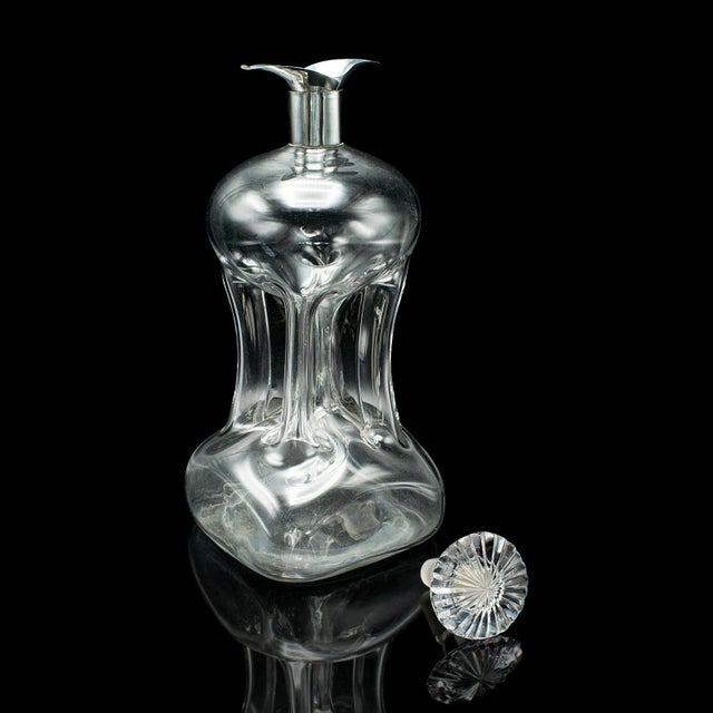 This is an antique spirit decanter. An English, glass and silver Port or Brandy bottle, dating to the early Edwardian...