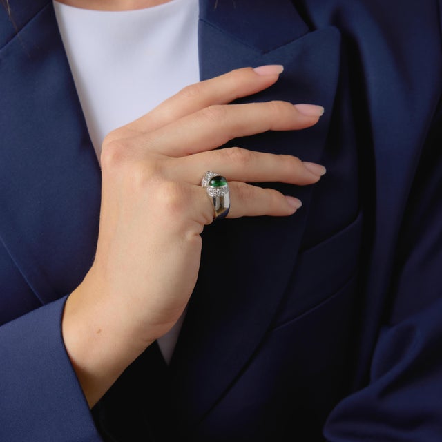 This elegant vintage ring showcases a smooth cabochon tourmaline, glowing with rich color and a soft, luminous surface....