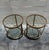 A refined pair of two-tier side tables featuring inset glass shelves framed by warm brass-tone metal and detailed with an...