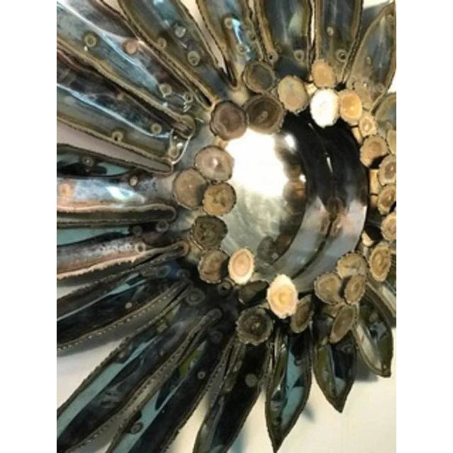 A sensational torch-cut mixed-metal with brass rain drop wall mirror with sunburst design by Curtis Jere, circa 1970. The...