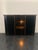 Elegant storage cabinet with 2 side doors and central sliding glass. The cabinet is lacquered black the central smoked...