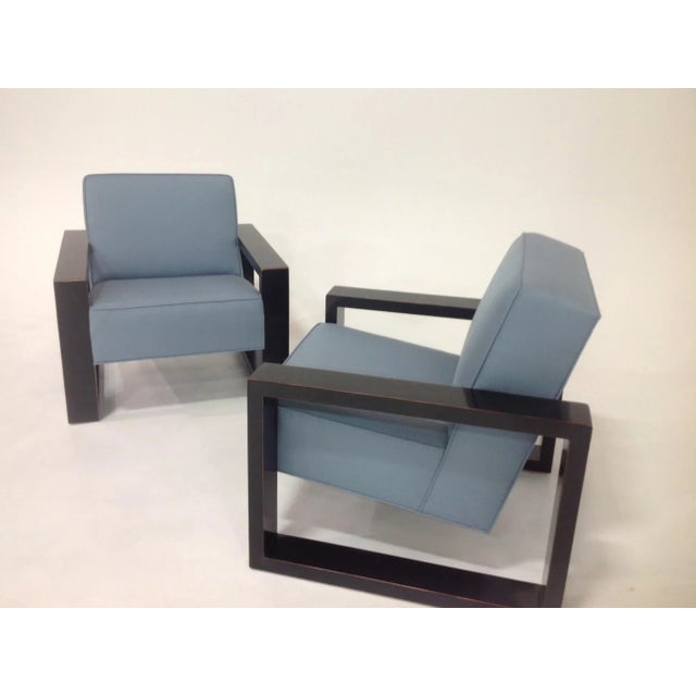 Modern pair of lounge chairs. Chairs are done in a blue chenille. The finish is a dark chocolate. The frames are made of...
