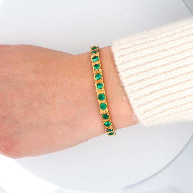 Vintage 18K yellow gold bracelet featuring 26 high-quality Colombian emeralds totaling 7.0 carats set in individual box...