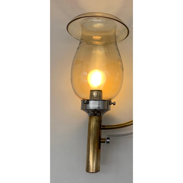 These are two vintage-style wall sconces with chromed metal, brass, and iron frames. The smoky amber blown glass diffusers...
