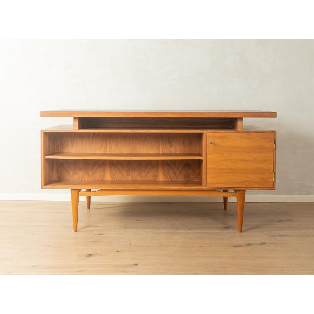 Classic freestanding desk from the 1960s. The body is finished in walnut veneer and features three drawers, a cabinet...