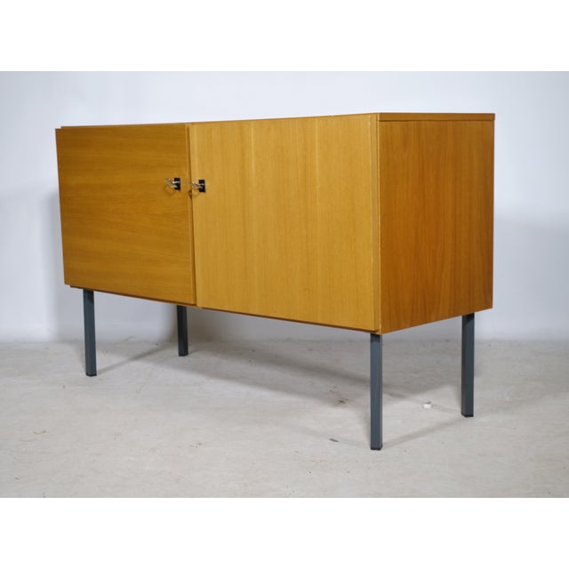 Timeless mid-century design sideboard in wood with metal legs from the 1960s. Two-door cabinet with a clean, minimalist...