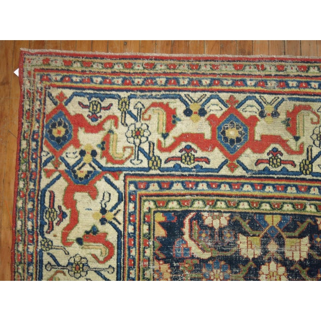 A naturally worn Persian doroksh rug with a traditional pallete in navy orange and ivory colors from the early 20th...