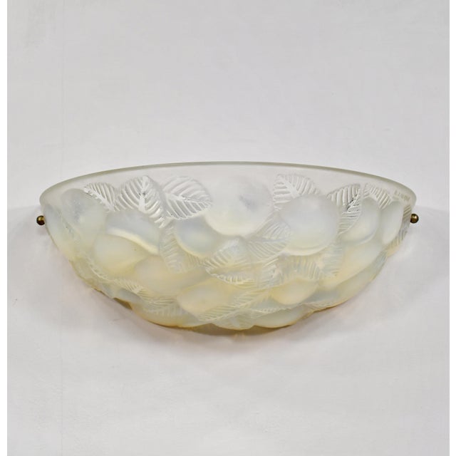 RENÉ LALIQUE A large French art deco wall sconce in opalescent semi-crystal. This model is called "Lausanne". A half-bowl...