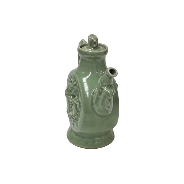 This celadon green ceramic ewer, possibly from the renowned Longquan Kiln, features a magnificent dragon (Loong) motif,...