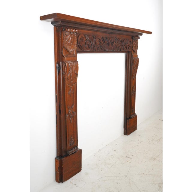 Victorian style mantel made of carved oak on a heart pine base featuring several griffins and perhaps dolphin heads,...