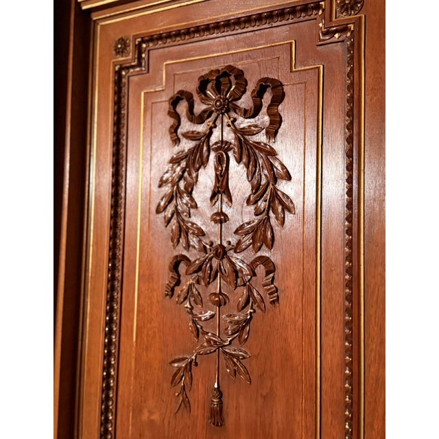 19th Century Louis XVI French Walnut Triple-Mirrored Armoire A striking and highly refined 19th century French armoire in...